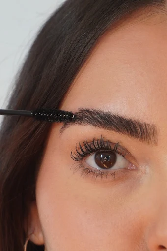 A spoolie brushing through a freshly laminated brow.