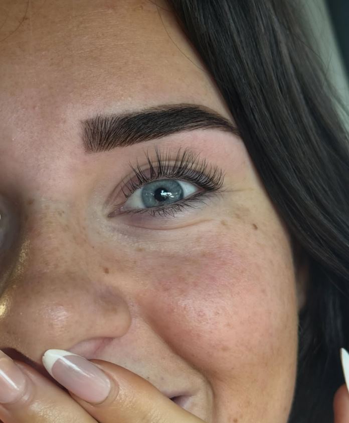 Close up of a laminated brow above a lifted, tinted lash line.